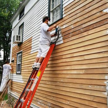 Delta Construction - a man on a ladder painting a house - General Contractors Near Me Delta Construction - a man on a ladder painting a house - General Contractors Near Me