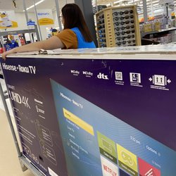 Sales associate assisting with the second tv with open box,