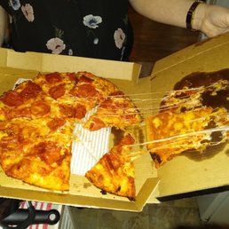 a woman holding a box of pizza