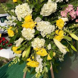 Deluxe White Tribute Spray customized with yellow flowers. Amazing and beautiful arrangement. Deluxe White Tribute Spray customized with yellow flowers. Amazing and beautiful arrangement.
