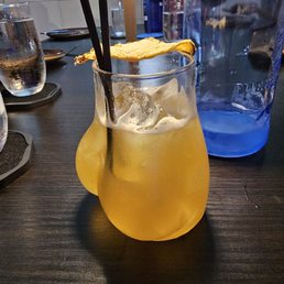 Spicy pineapple zero proof whisky cocktail in a glass that looks like...