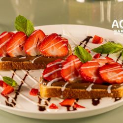 Aqua Bar & Grill - Nutella and Strawberry Toast
Hazelnut cocoa spread with fresh strawberries, fresh mint, and a chocolate drizzle.
Add: One egg* 2