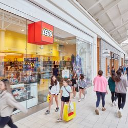 Shoppers walk past the LEGO Store and Urban Outfitters at Danbury Fair.