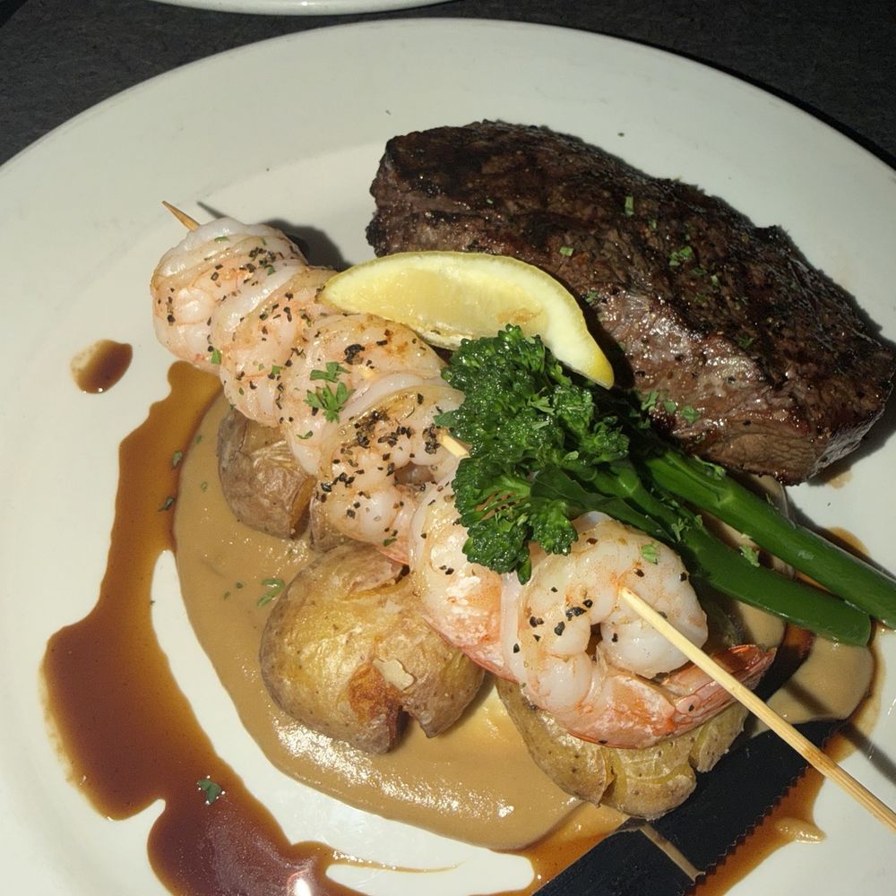 Hume Hotel - Steak &Prawns 10oz Reserve Angus Beef Striploin Garlic Prawn Skewer|Broccolini SoubiseCrushed Lemon & Garlic Potatoes Port Wine Jus - Hotels Near Me - Nelson, British Columbia Hume Hotel - Steak &Prawns 10oz Reserve Angus Beef Striploin Garlic Prawn Skewer|Broccolini SoubiseCrushed Lemon & Garlic Potatoes Port Wine Jus - Hotels Near Me - Nelson, British Columbia