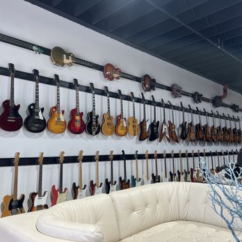 The Guitar Broker - An assortment of vintage Gibson guitars on the top rack An assortment of vintage Fender guitars on the bottom - Guitar Stores Near Me - Ft. Lauderdale, Florida
