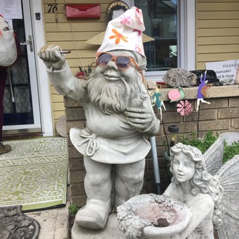 Polka Dot - Gnome outside Polka Dot - she jazzes him up funny sometimes - A garden gnome statue with sunglasses and a cloth hat, holding a pipe, stands next to a fairy statue holding a bowl. The scene is outside a house with decorative items. - Cafes Near Me - High Bridge, New Jersey