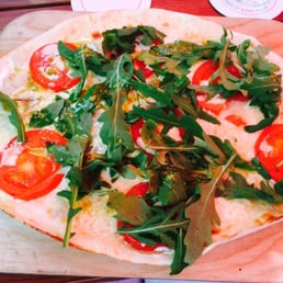 Flammkuchen with tomatoes, mozzarella, and rocket. Flammkuchen with tomatoes, mozzarella, and rocket.