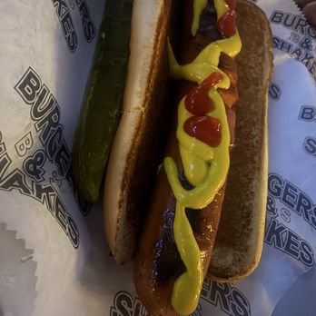 Burgers and Shakes - Angus hot dog with a pickle. We added the mustard & ketchup. - Burgers Near Me - Miami Beach, Florida Burgers and Shakes - Angus hot dog with a pickle. We added the mustard & ketchup. - Burgers Near Me - Miami Beach, Florida