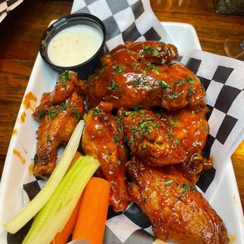 Mixxed DC - Mumbo Wings - Buffalo chicken wings served with celery and carrot sticks, accompanied by a side of ranch dressing in a black cup. - Burgers Near Me - Washington, DC, District of Columbia