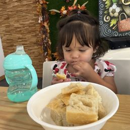My granddaughter enjoying Tosca's delicious and fresh focaccia bread. My granddaughter enjoying Tosca's delicious and fresh focaccia bread.