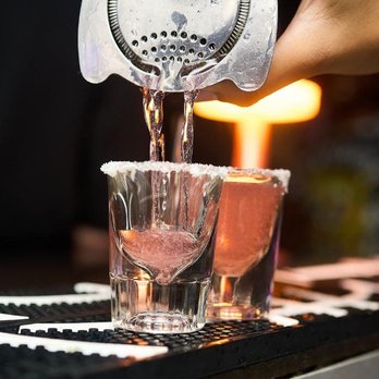 SHOTS - Orlando - a bartender pouring a drink - Bars Near Me - Orlando, Florida SHOTS - Orlando - a bartender pouring a drink - Bars Near Me - Orlando, Florida