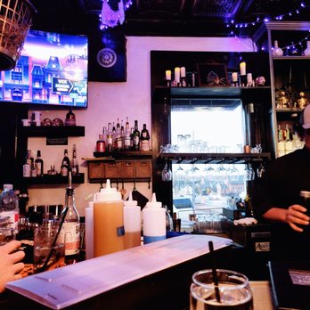 Mercantile Social - a man and a woman sitting at a bar - Tapas/Small Plates Near Me - Alpharetta, Georgia