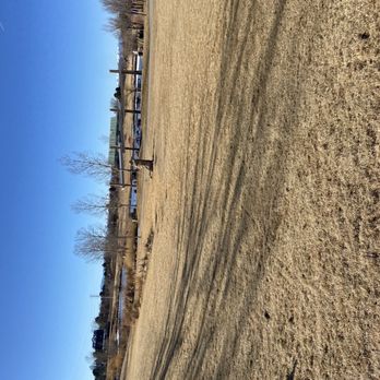 Utah Park - A spacious park with dry grass, leafless trees, and a clear blue sky, featuring a wooden fence and some distant structures. - Parks Near Me - Aurora, Colorado
