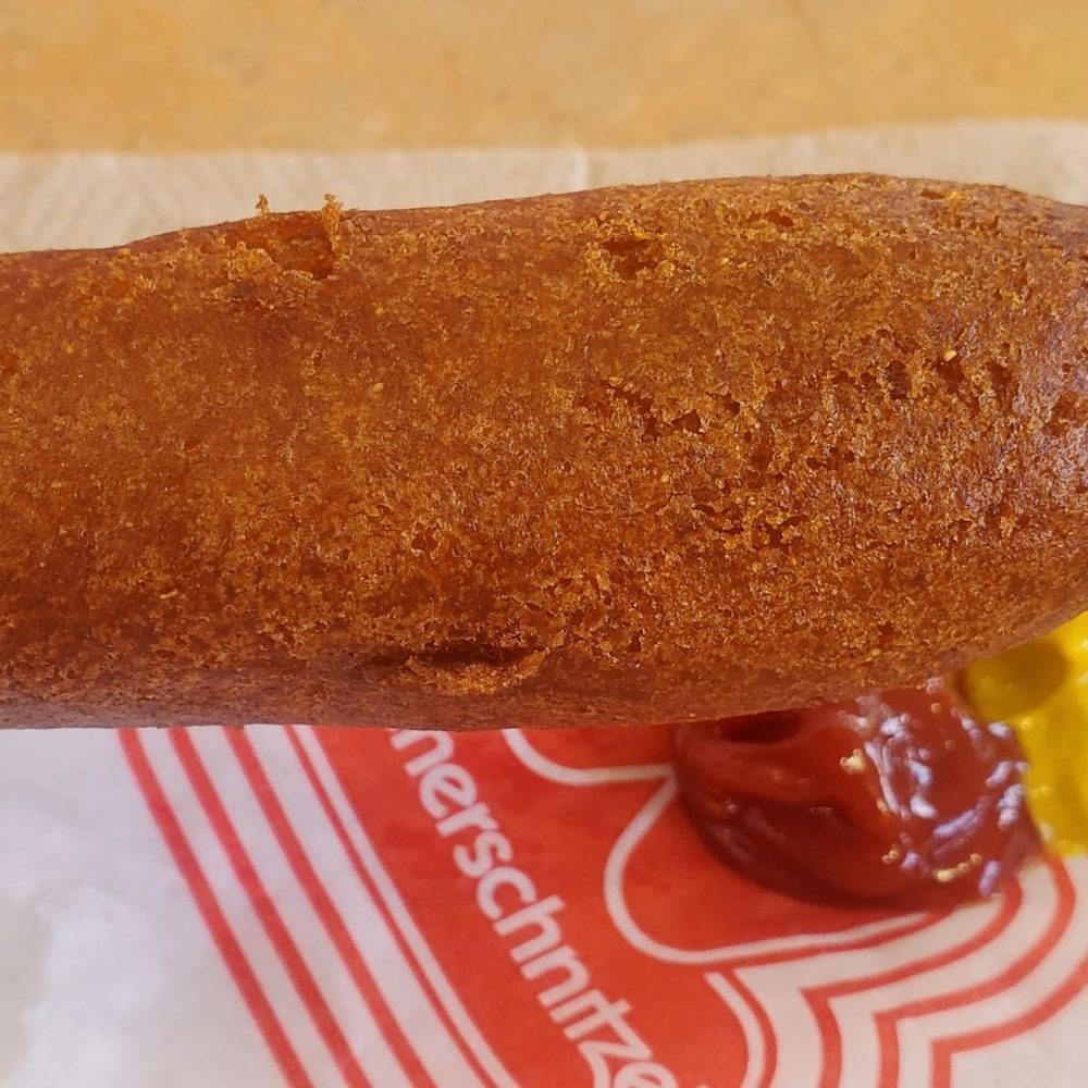 Wienerschnitzel - A hot and fresh corn dog going in for a dip of ketchup and mustard! - Fast Food Near Me - Modesto, California