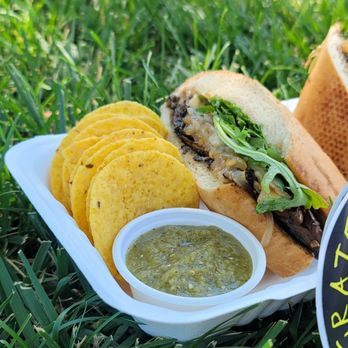 Grateful Planet Foods - a sandwich and chips in a styrofoam container - Vegan Near Me