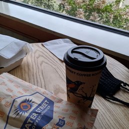 a cup of coffee and a sandwich on a table a cup of coffee and a sandwich on a table