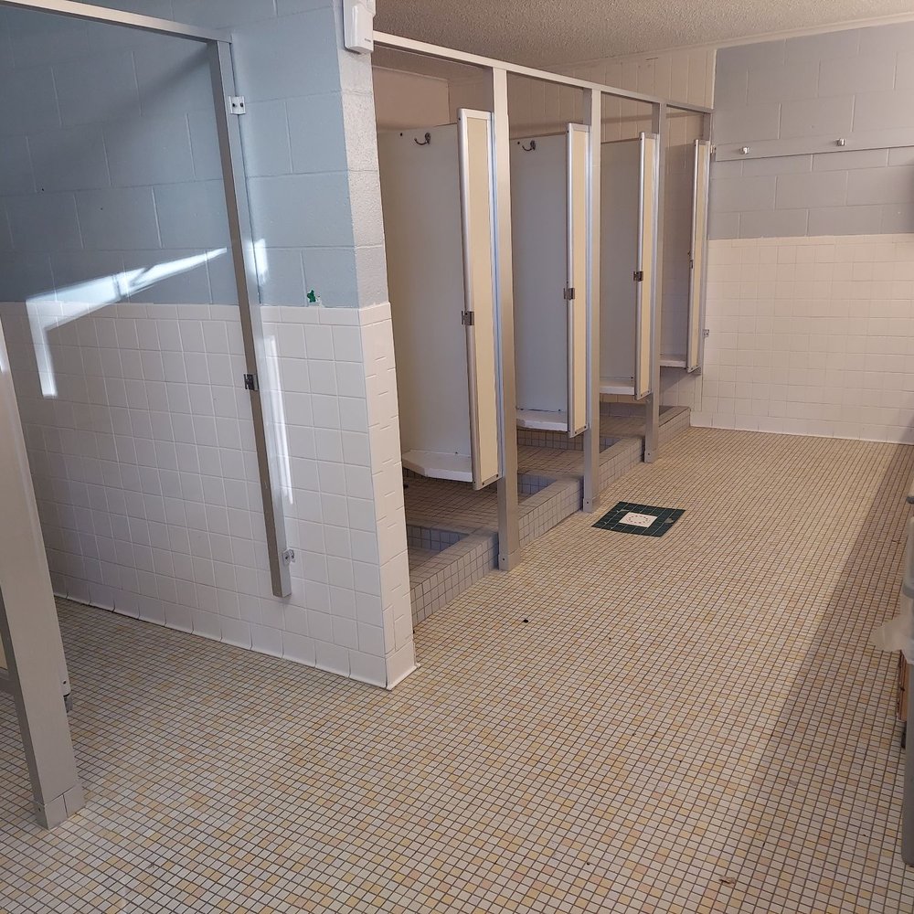Toilet stalls to the left, and showers to the right. Toilet stalls to the left, and showers to the right.