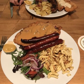 Wurst & Schnitzelhaus - WuSH - Schnitzel and sausages in foreground w/spaetzle and a different selection in the background w/fried potatoes - German Near Me - Amsterdam, New Hampshire Wurst & Schnitzelhaus - WuSH - Schnitzel and sausages in foreground w/spaetzle and a different selection in the background w/fried potatoes - German Near Me - Amsterdam, New Hampshire