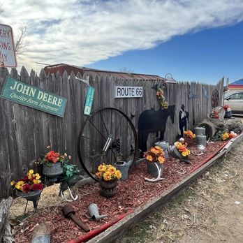 Hamburger Station - a wooden fence with flowers and signs - Burgers Near Me - Pampa, Texas