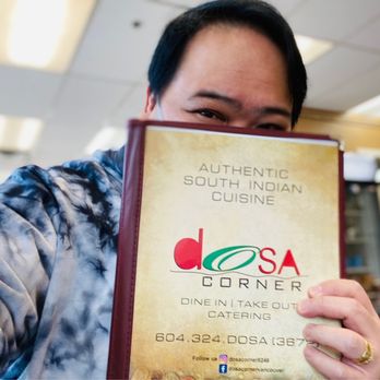 Dosa Corner - a man holding up a menu - Indian Near Me - Vancouver, British Columbia