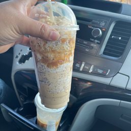 a hand holding a cup of iced coffee