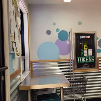 Coin-Op Laundry - The token machine ( doesn't always work), and the bulletin board. - Laundromat Near Me - Waldport, Oregon
