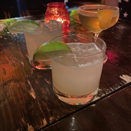 three cocktails on a wooden table three cocktails on a wooden table