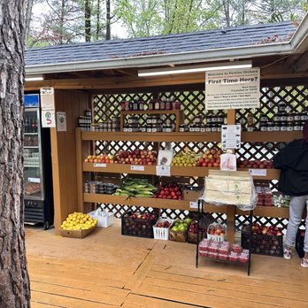 Perkins Orchard - a woman standing in front of a fruit stand - Farmers Market Near Me - Durham, North Carolina