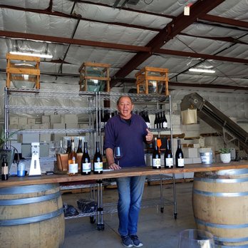 Two Moons Cellars - a man holding a glass of wine - Wine Tasting Room Near Me - Paso Robles, California