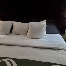 King size bed with 4 small throw pillows to sleep on.