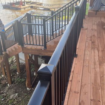 Next Phase Projects - Cedar-tone deck with black metal railing at The Lake of The Ozarks. - Flooring Near Me - Columbia, Missouri Next Phase Projects - Cedar-tone deck with black metal railing at The Lake of The Ozarks. - Flooring Near Me - Columbia, Missouri