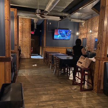 District - a woman sitting at a table in a restaurant - Bars Near Me - Portsmouth, Virginia