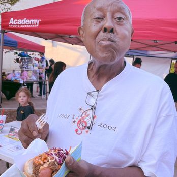 Haute Dog - an old man holding a hot dog - Food Stands Near Me
