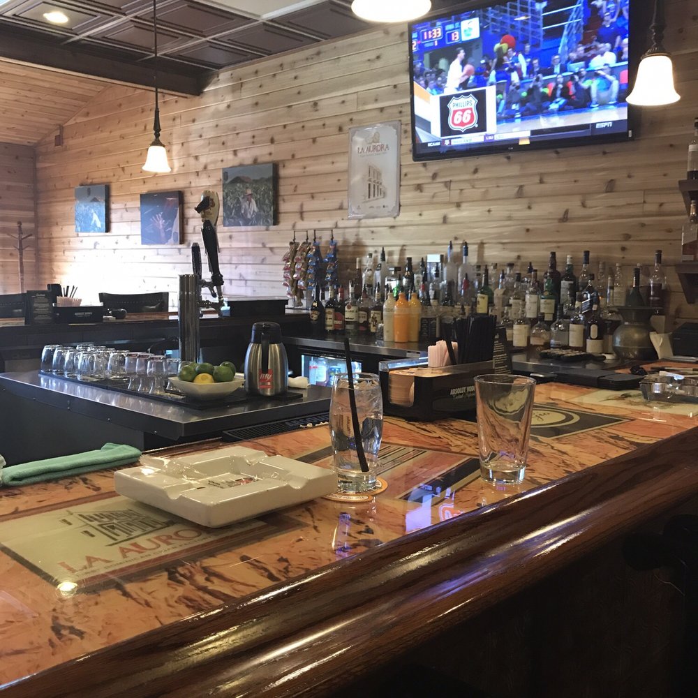 a bar with a large screen tv a bar with a large screen tv