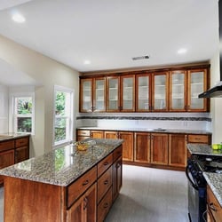 Stain grade kitchen in Sacramento featuring an entire wall of upper cabinets with inset glass panels
