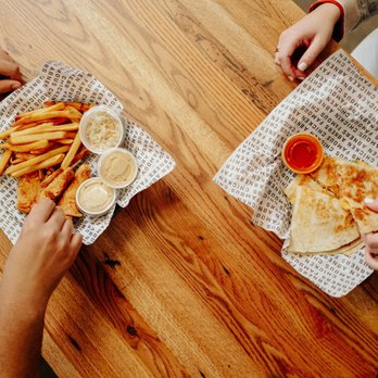 Abner's Famous Chicken - two people eating pizza and fries - Chicken Wings Near Me - Brandon, Mississippi