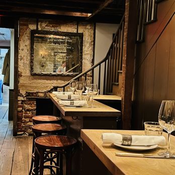 Chez Nous - a restaurant with wooden tables and stools - French Near Me - Charleston, South Carolina