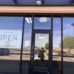 Anytime Fitness - We're open 24/7 sign next to we're closed sign and posted hours of operation (not 24/7)