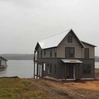 Norman Construction - a two story house on the shore of a lake - General Contractors Near Me - Hattiesburg, Mississippi