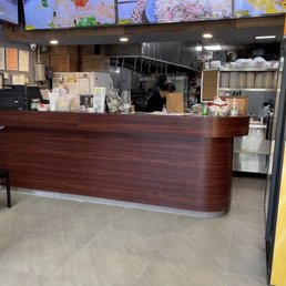 a restaurant with a counter and televisions a restaurant with a counter and televisions