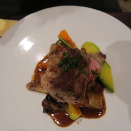 Pork on top of mashed potatoes and seasonal vegetables