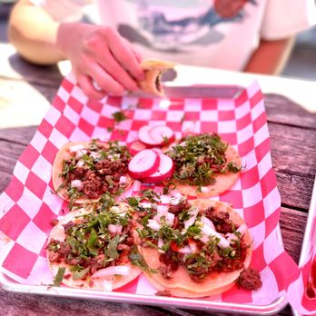 Tacos Tecalitlan - a person putting toppings on a taco - Food Trucks Near Me - Burlington, Washington