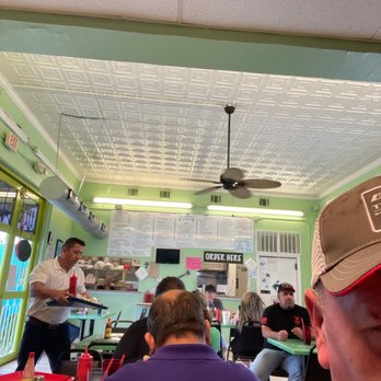 The Lighthouse Seafood - a man wearing a hat in a restaurant - Seafood Near Me - San Antonio, Texas