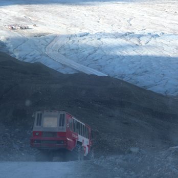 Columbia Icefield Glacier & Centre - Headed down a steep hill, and the destination (by the other Explorers) is in view in the distance. - Visitor Centers Near Me - Jasper, Alberta