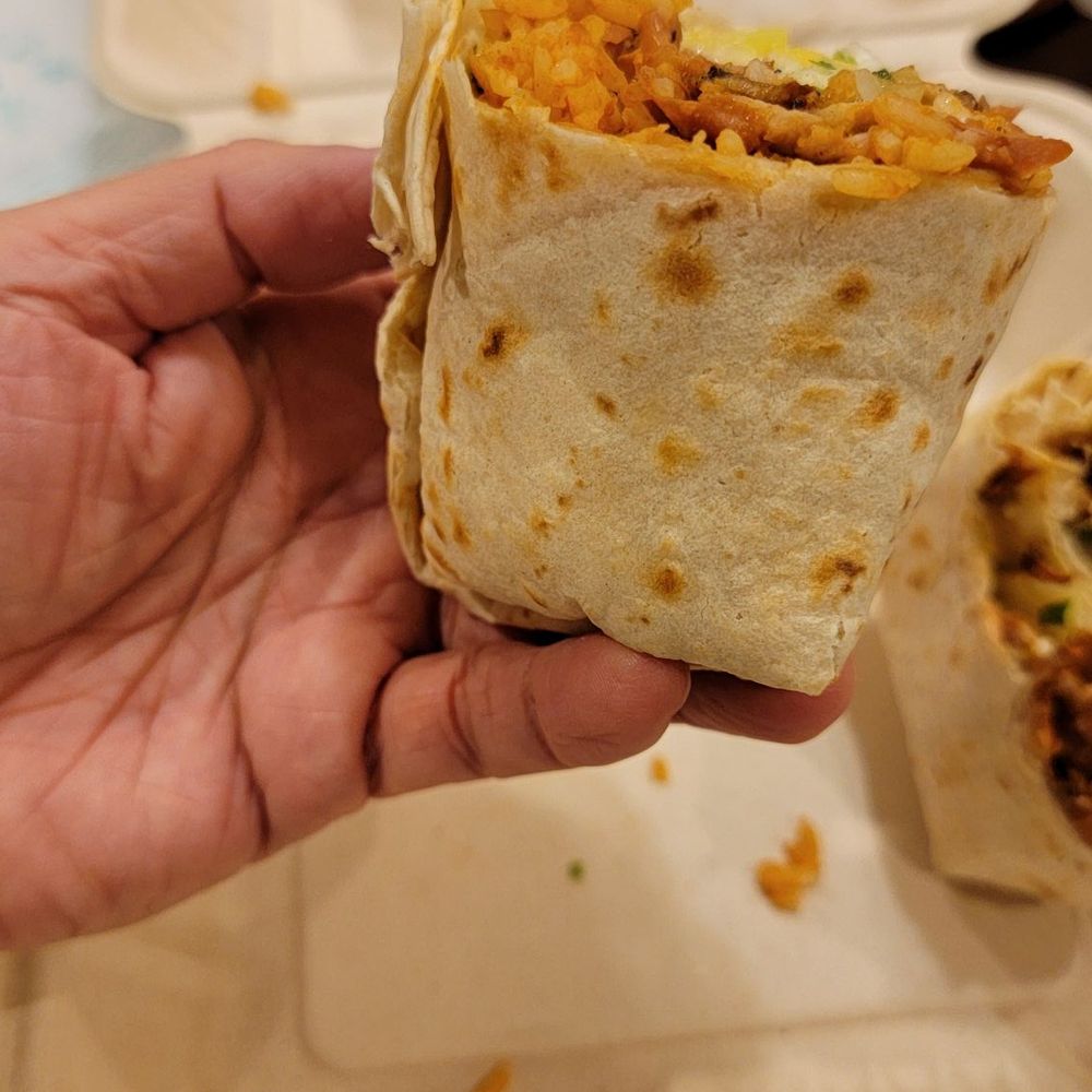 Taquito Lindo - Half of the Al pastor burrito (pre-cut by the restaurant) in my medium sized hand. Very small burrito for $17 - Tacos Near Me - Williamsville, New York Taquito Lindo - Half of the Al pastor burrito (pre-cut by the restaurant) in my medium sized hand. Very small burrito for $17 - Tacos Near Me - Williamsville, New York