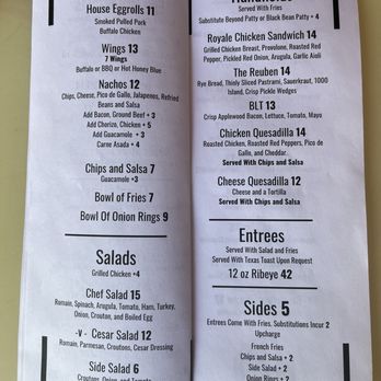 Bisbee Royale - Appetizer salad, and sandwich menu - A restaurant menu with two pages displays a variety of food options including starters like house eggrolls and nachos, hand-helds such as Royale Chicken Sandwich and The Reuben, salads, entrees, and sides. Vegetarian options are marked with a V. The menu provides detailed descriptions and prices for each item, including options for substitutions and additional charges. - Music Venues Near Me - Bisbee, Arizona