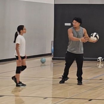 Angel Elite VBC - Coach Drew taking his time to go over proper serving technique. - Sports Clubs Near Me Angel Elite VBC - Coach Drew taking his time to go over proper serving technique. - Sports Clubs Near Me