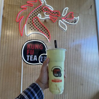Kung Fu Tea - Kung fu tea logo with dragon, holding honeydew mania slush drink with mango jelly - Bubble Tea Near Me - Rockford, Illinois Kung Fu Tea - Kung fu tea logo with dragon, holding honeydew mania slush drink with mango jelly - Bubble Tea Near Me - Rockford, Illinois