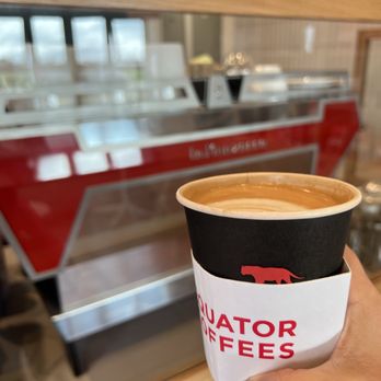 Equator Coffees - a person holding a cup of coffee - Coffee & Tea Near Me - Laguna Beach, California