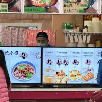 99 BBQ House - a man standing in front of a display of food - Barbeque Near Me - Burnaby, British Columbia